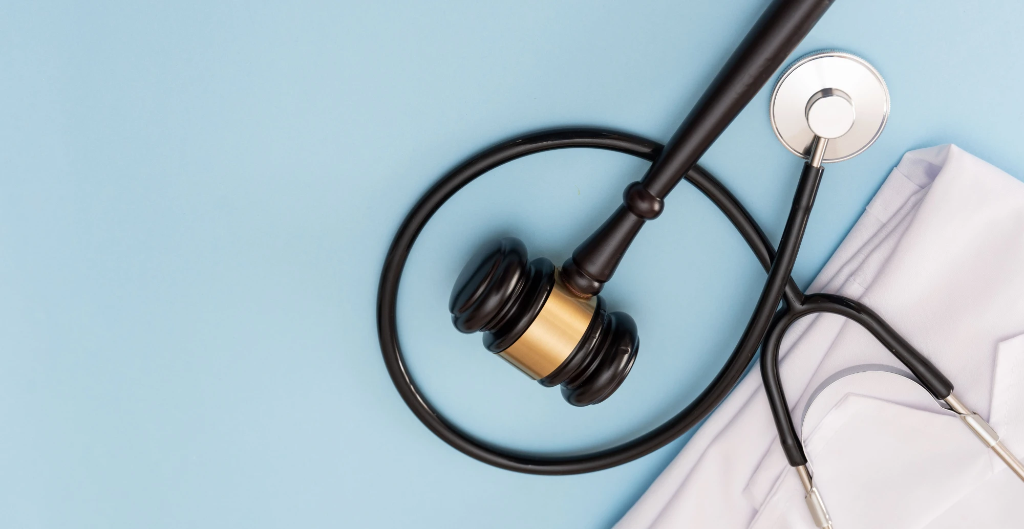 Stethoscope with gavel on blue background representing healthcare compliance