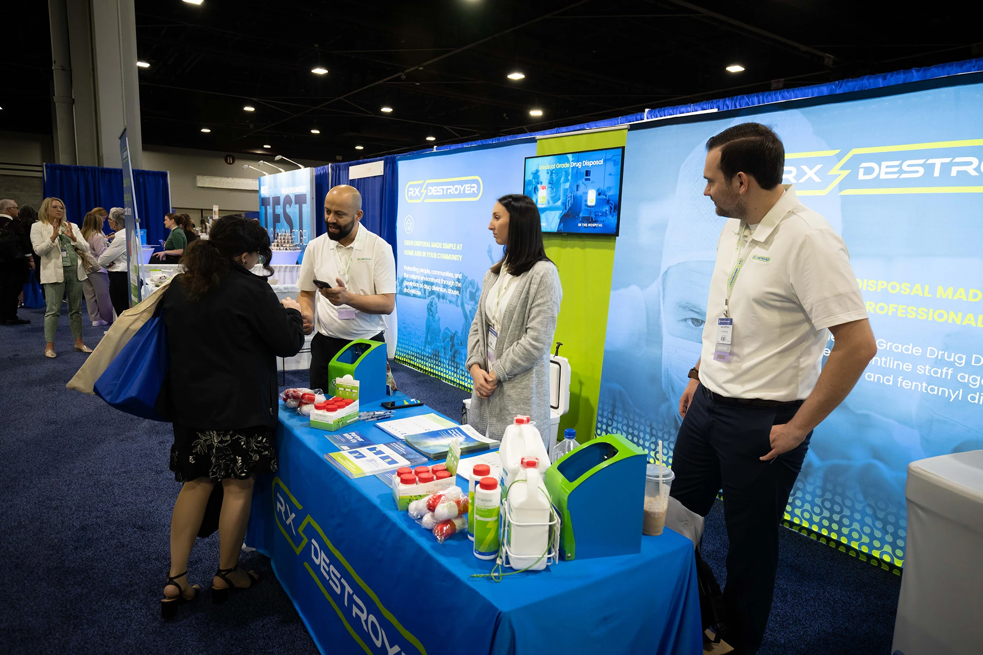Rx Destroyer team members at trade show booth with branded signage and product displays
